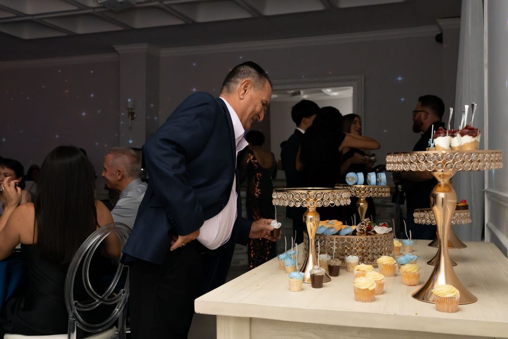 Dessert display table with tiered stands and treats at an elegant evening reception.