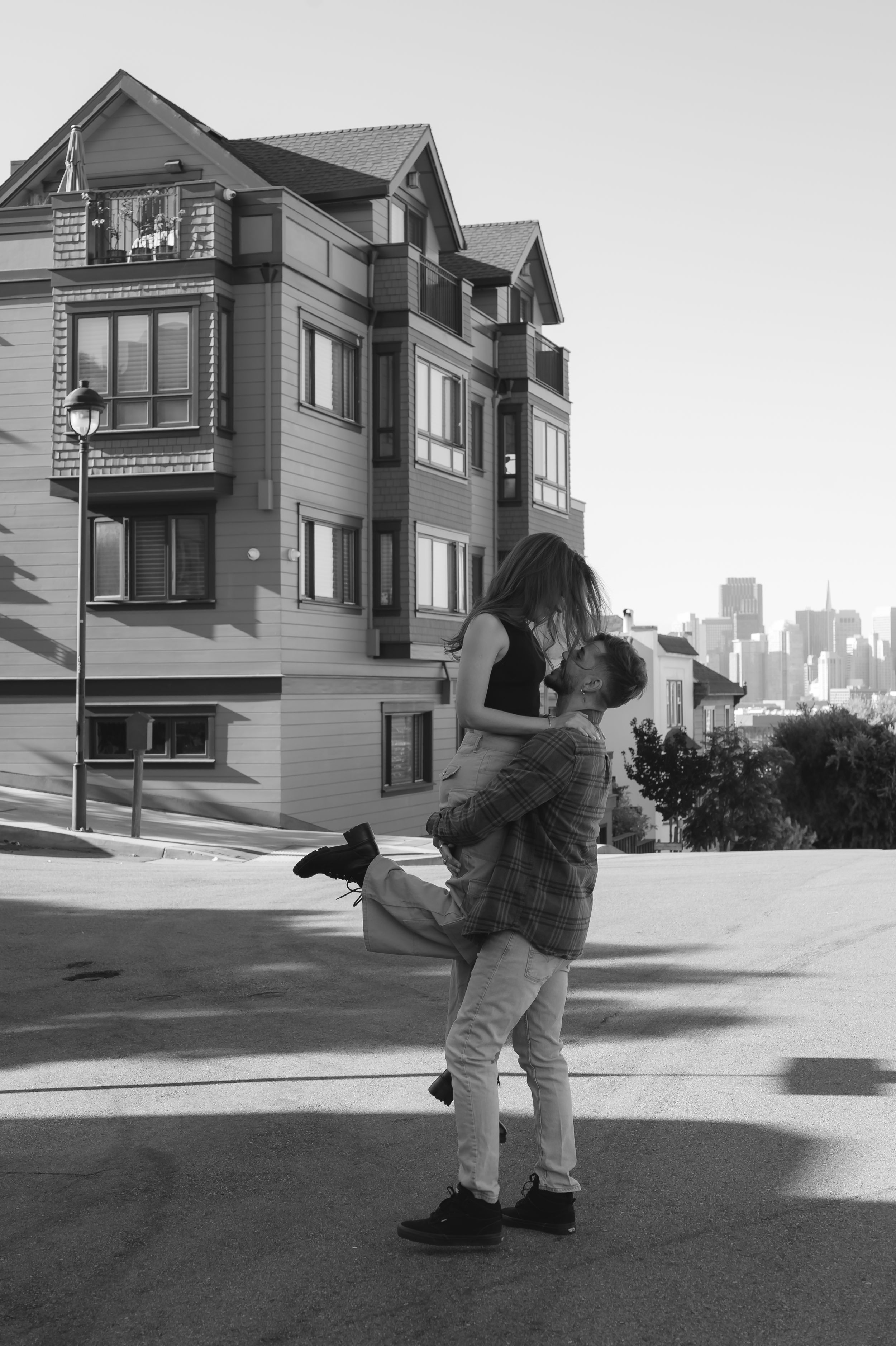 Black and white series of two people dancing outdoors with residential buildings in background.