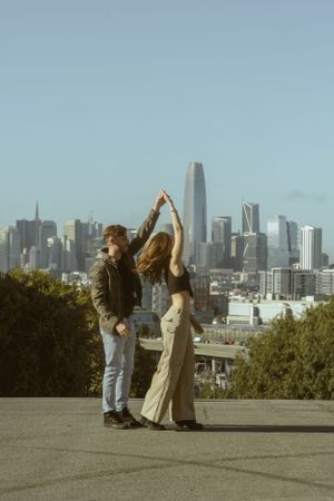 Dancing sequence against San Francisco skyline backdrop with blue sky.