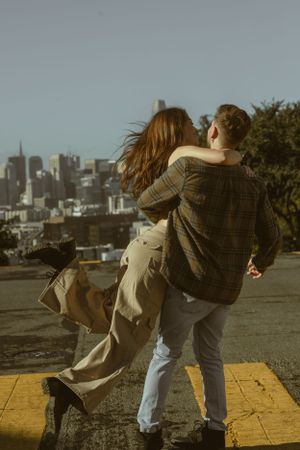 Playful dance moves captured in sequence with urban cityscape in background.