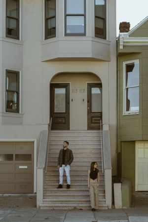 Couple standing on steps outside a classic San Francisco Victorian style building.