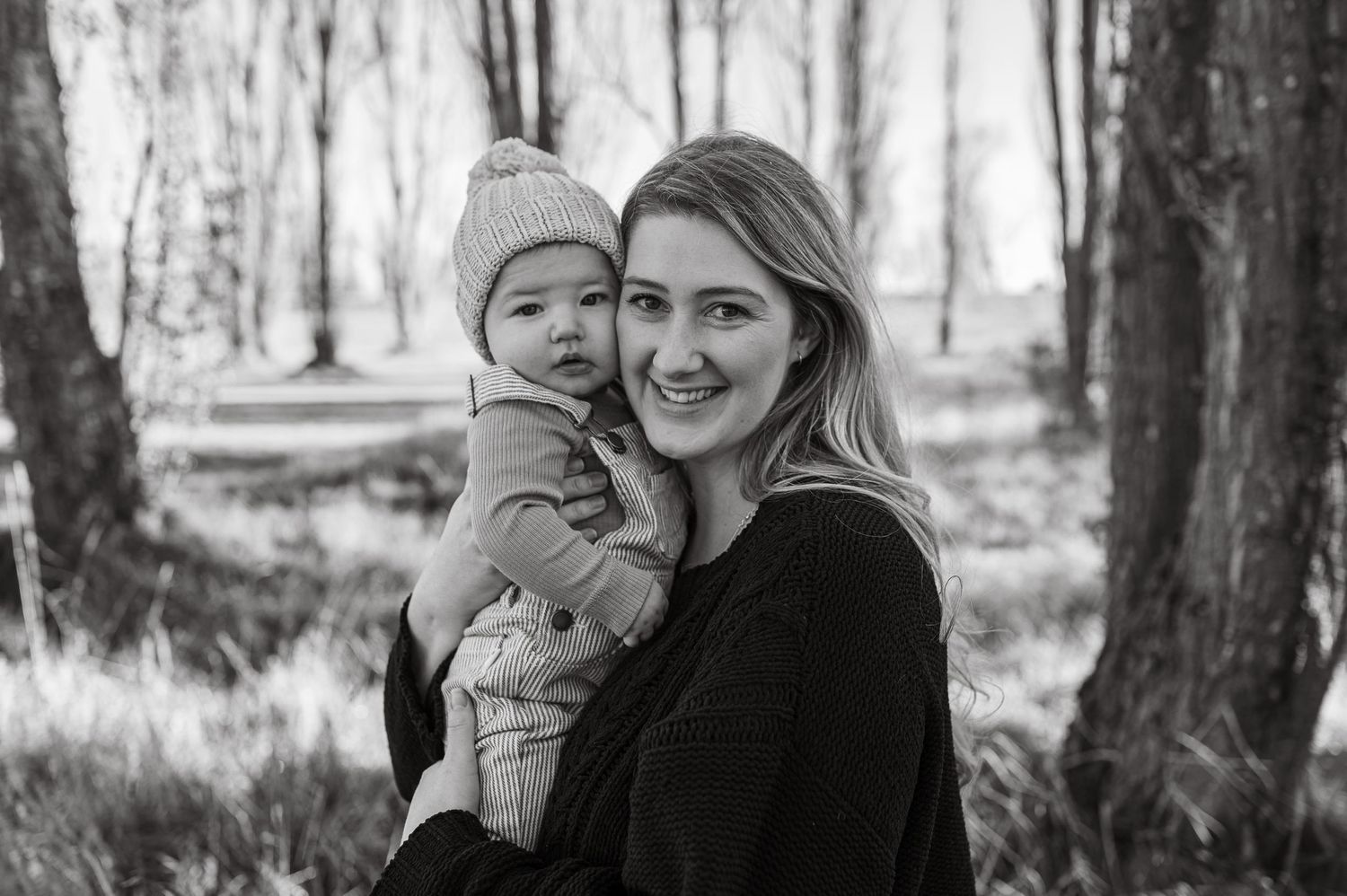 A winter forest scene with bare trees creates a dramatic black and white backdrop.