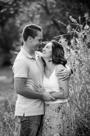 Black and white portrait of a husband and wife embracing affectionately during an outdoor shoot.