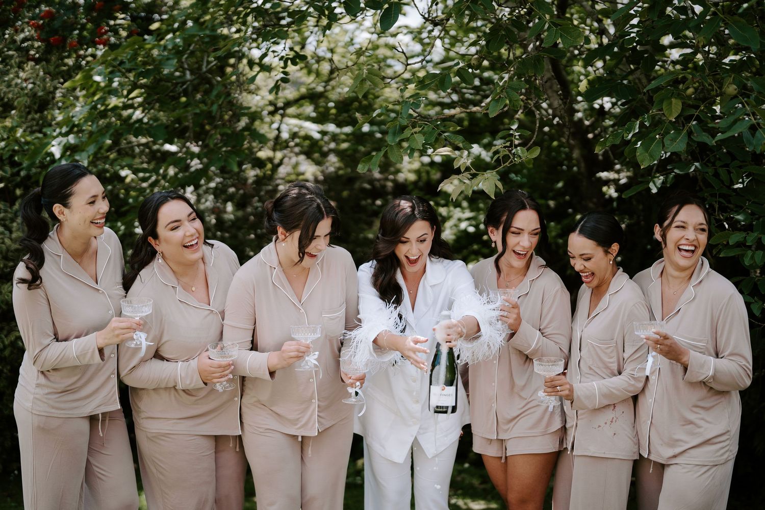 bride popping champagne with bridesmaids at the new inn cirencester