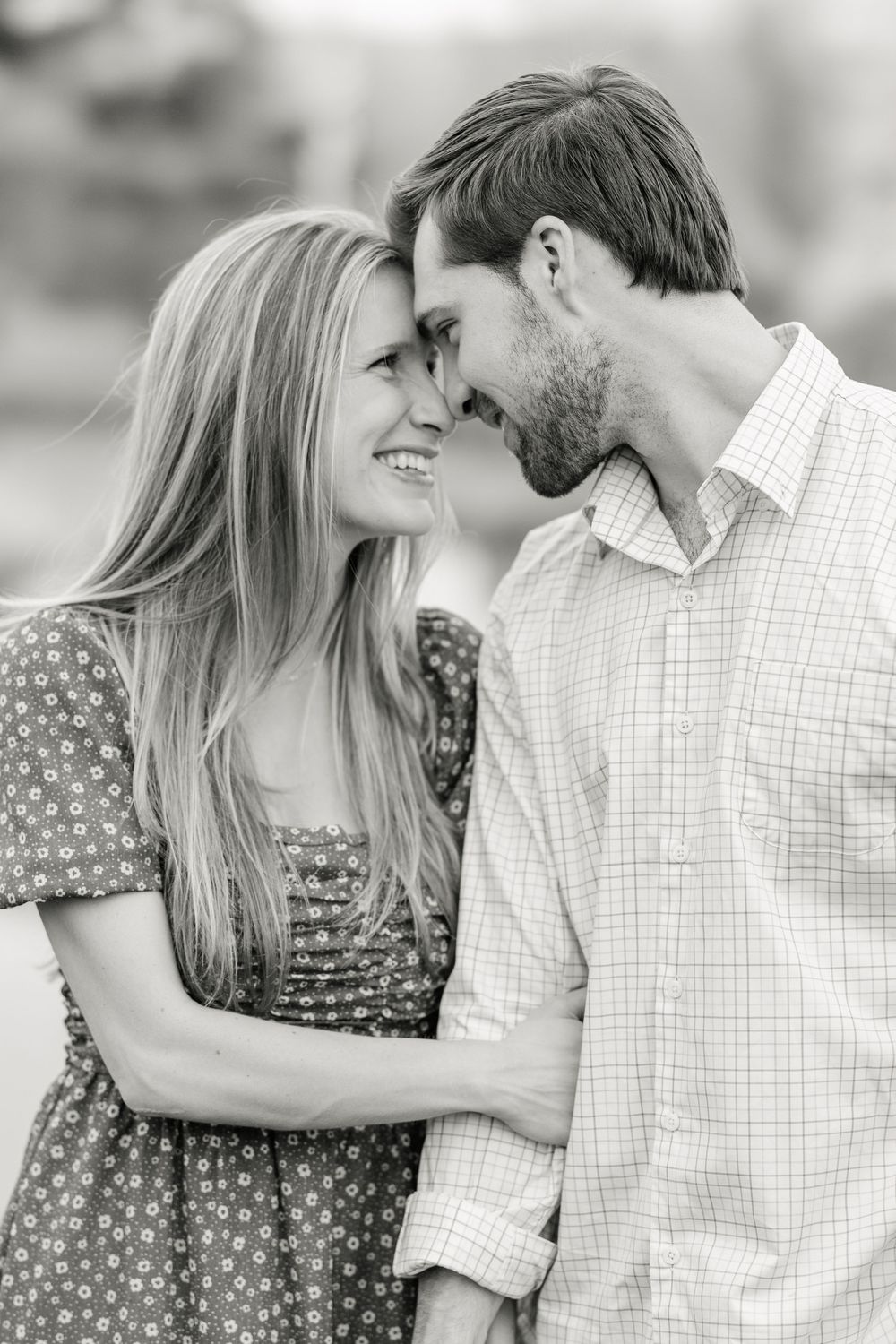 A romantic black and white portrait of a couple in casual attire sharing an intimate moment as they lean in close together in Warwick, New Y