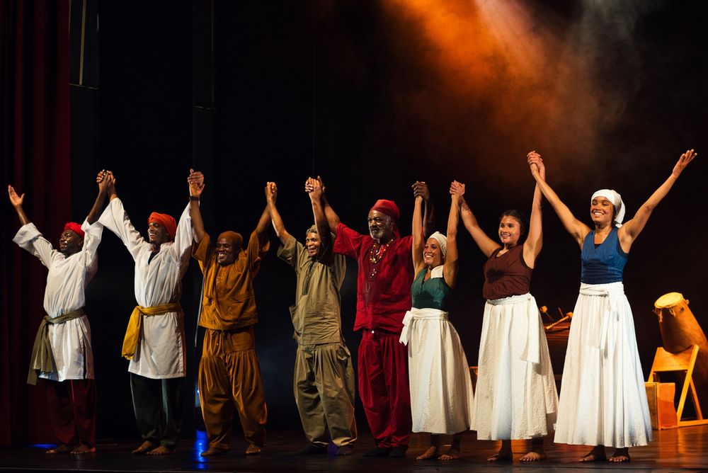 Cast members take final bow during curtain call of theatrical performance.