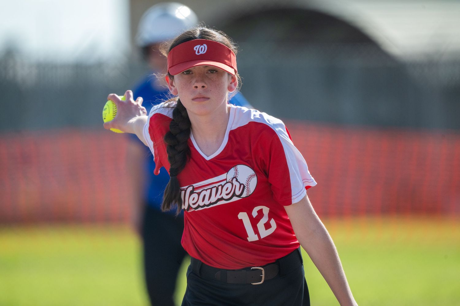 Baseball players in red uniforms during game action.