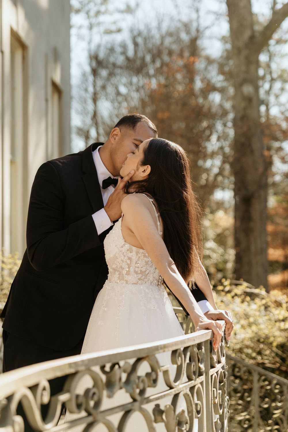 A bride and groom share a romantic kiss on an balcony of the Swan House in Atlanta, GA.