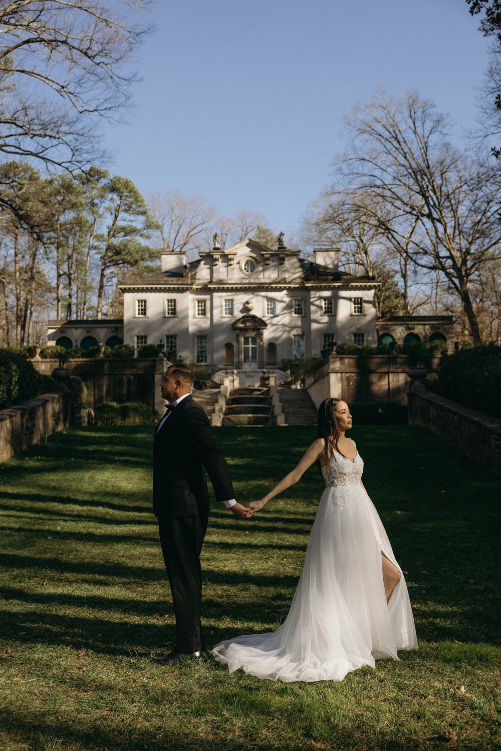 A wedding couple poses in front of an elegant historic mansion of the Swan House in Atlanta, GA.