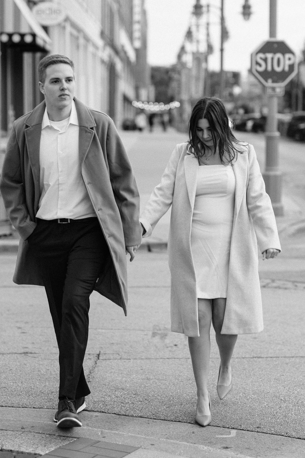 Black and white candid of couple crossing the street during an engagement session in Milwaukee