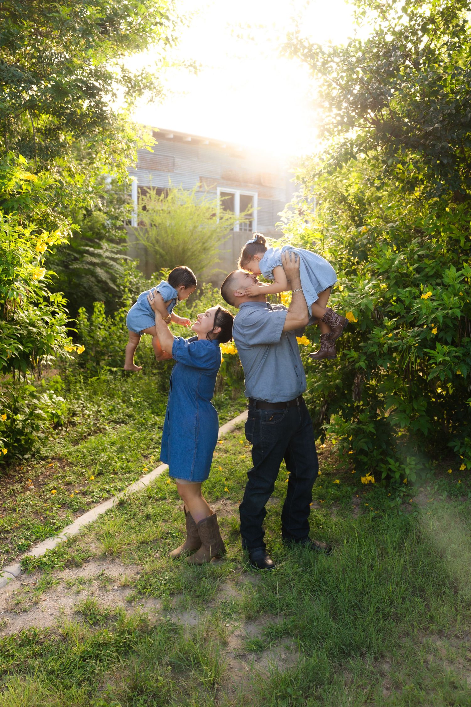 Happy family of three walking hand-in-hand on a brick path near a rustic building in autumn. Hidalgo, TX. Old Hidalgo Pumphouse. Photoshoot.