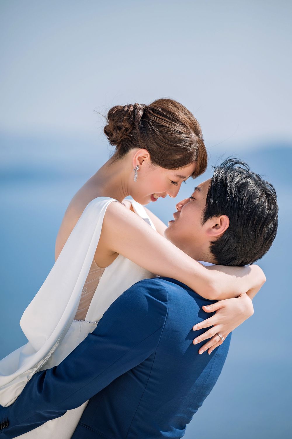 An intimate moment captured against the blue Mediterranean backdrop in Santorini.