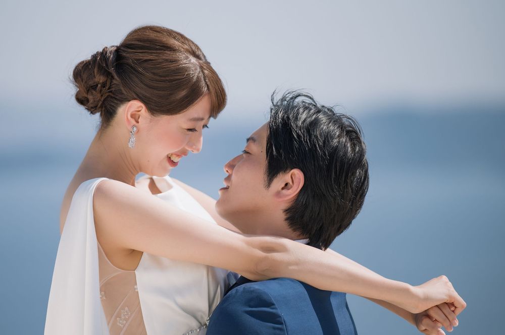 A romantic moment captured between couple embracing with ocean backdrop in Santorini.
