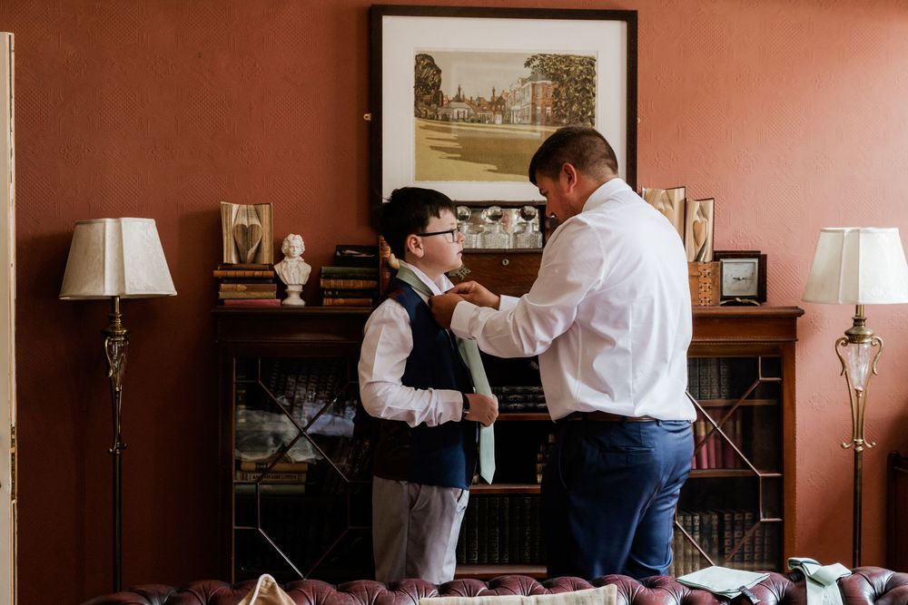 Groom getting boy ready at Gildredge Manor
