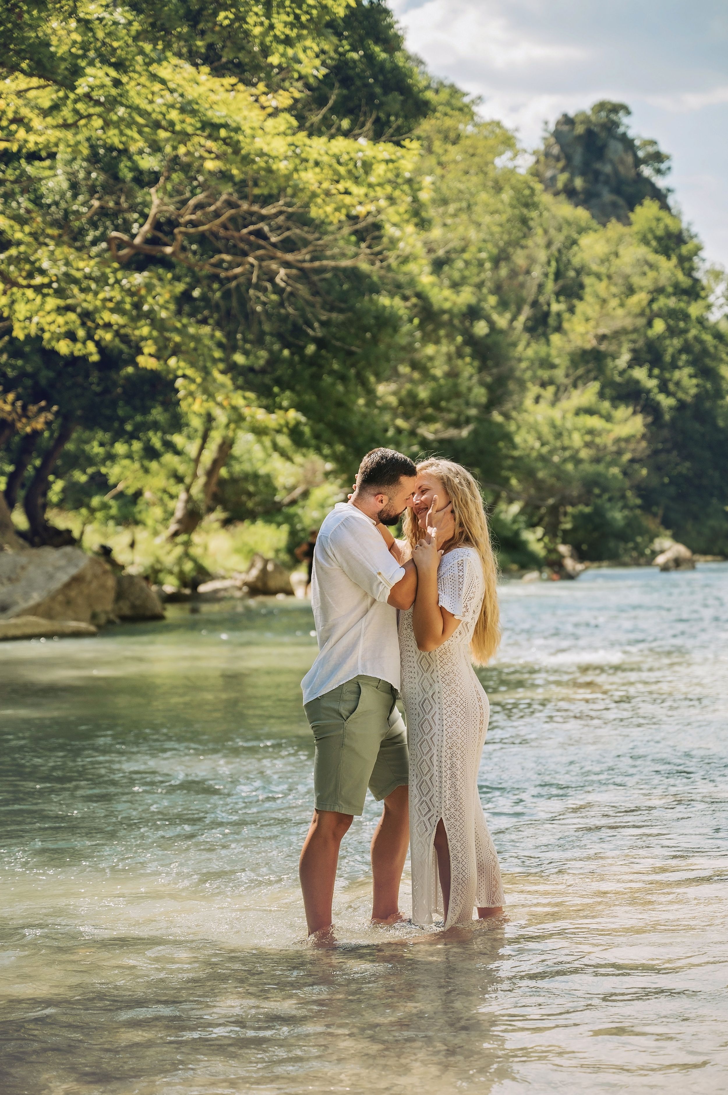 Couple shares emotional moment while standing in river during romantic photoshoot.