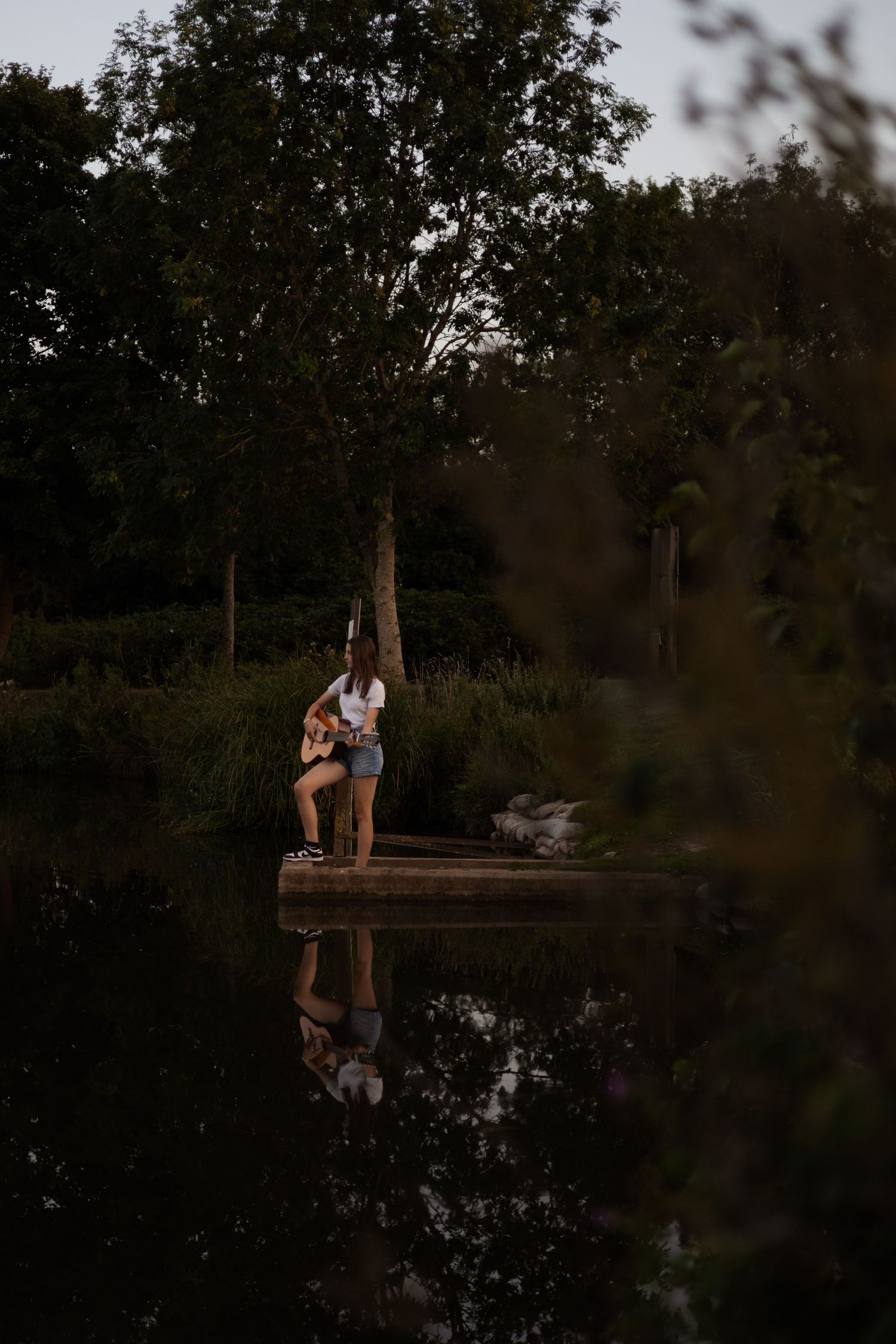 Girl playing guitar near a lake, senior session