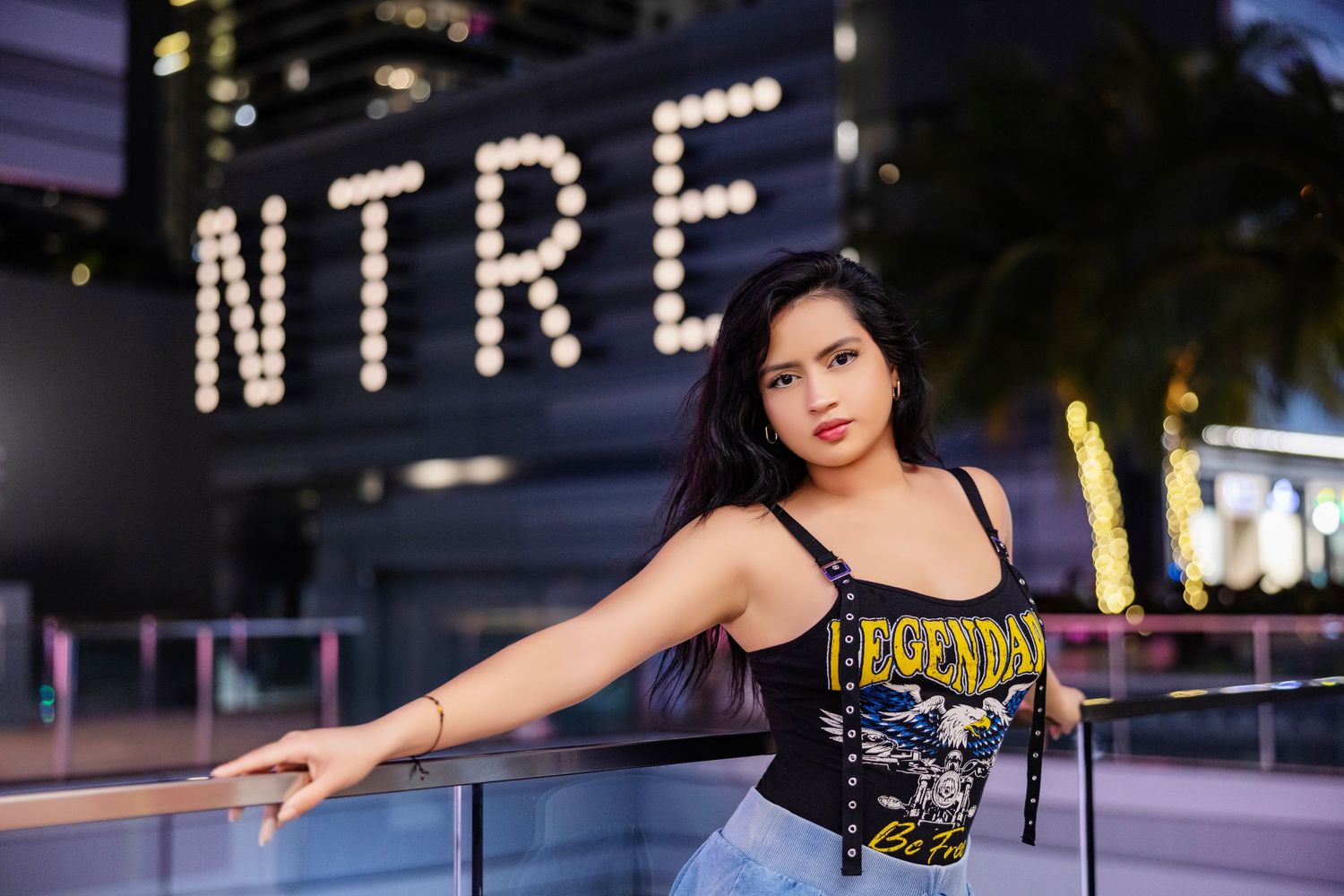 Urban nighttime photoshoot with illuminated signage and dramatic poses.
