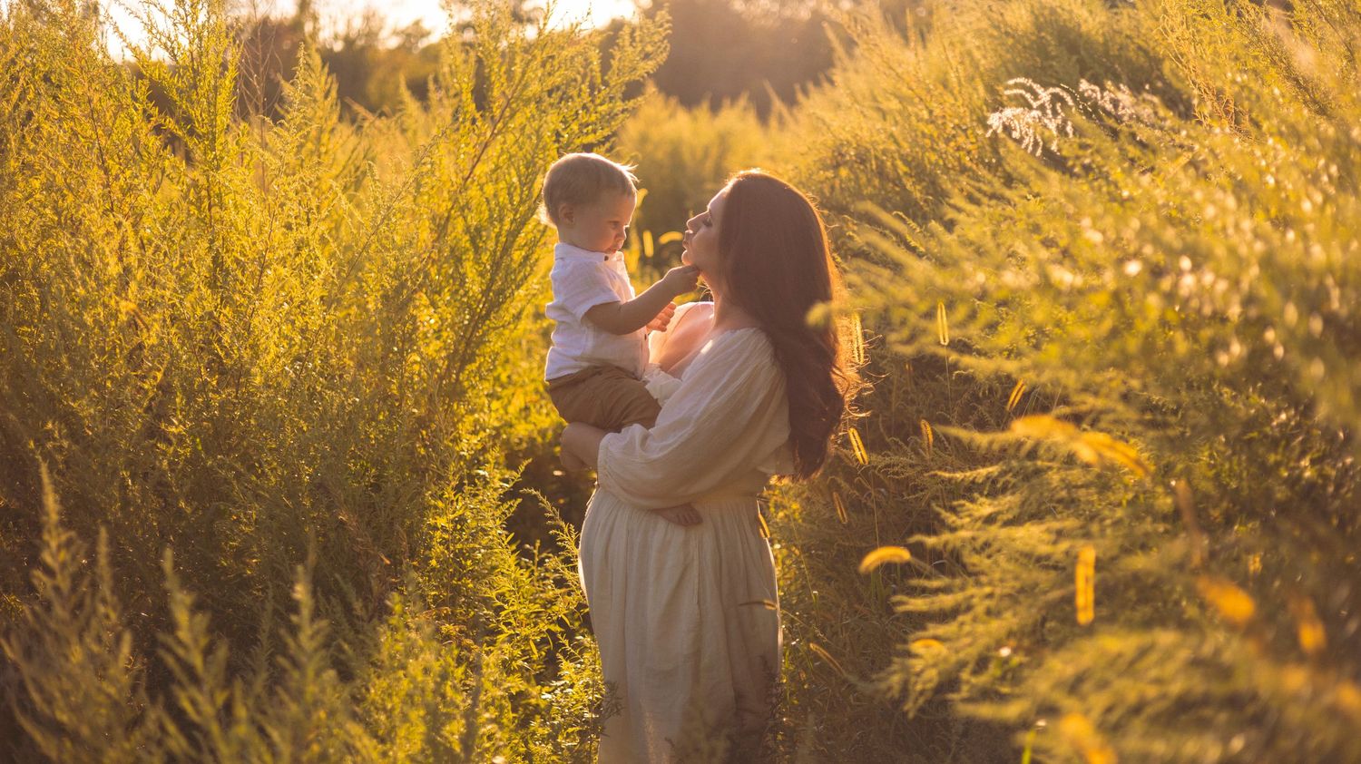 A golden-lit outdoor photo series shows someone in a white dress walking through tall grass at sunset.