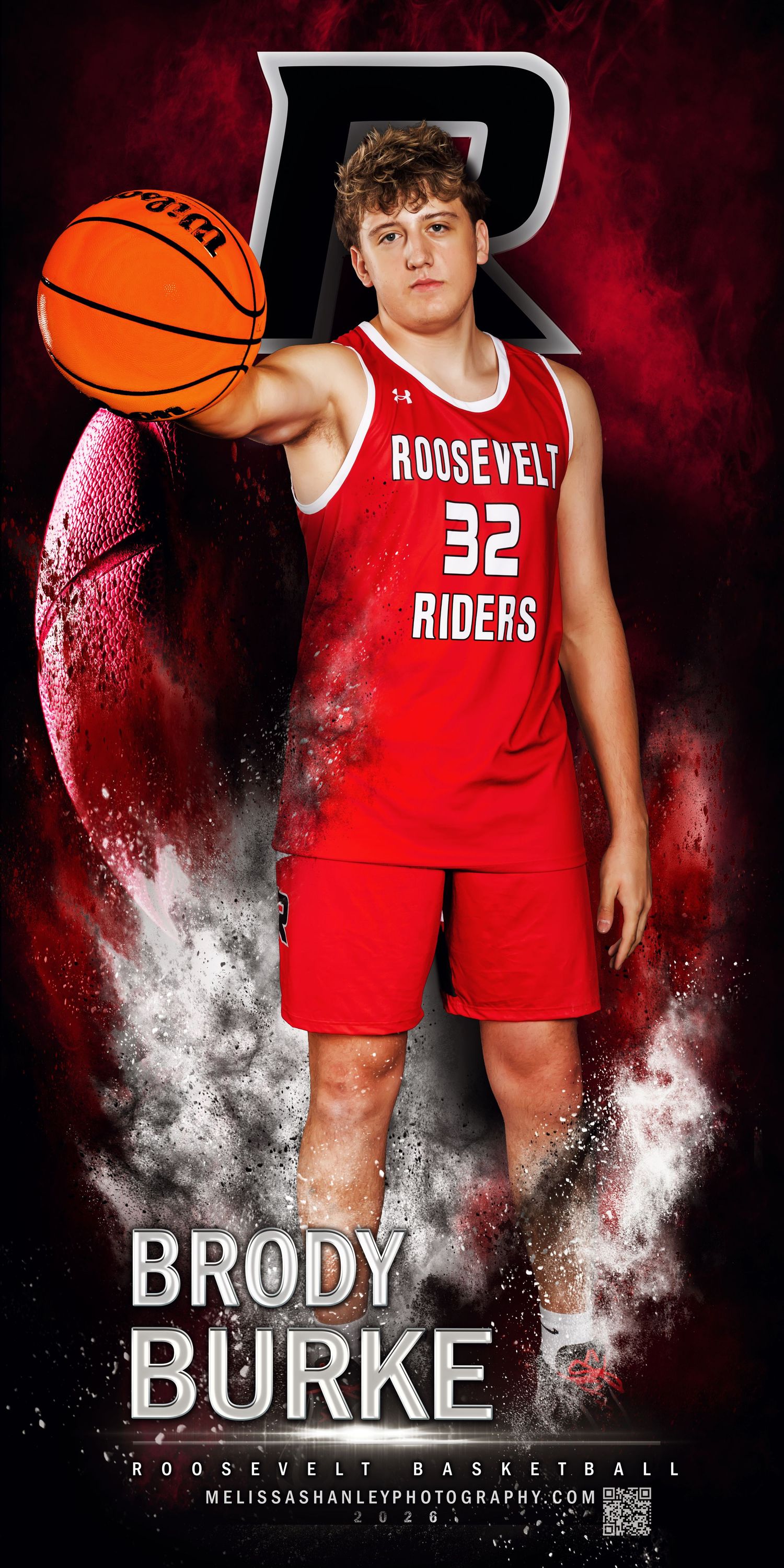 Basketball player in blue Broomfield uniform poses with ball against dramatic blue and white smoke background.