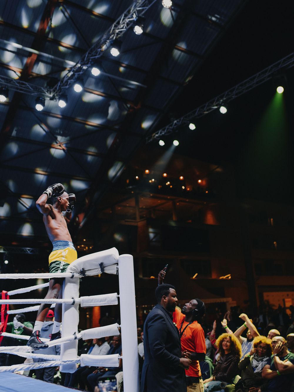 Dramatic boxing match moment captured at Kigali Fight Night showing boxers exchanging punches in the ring.