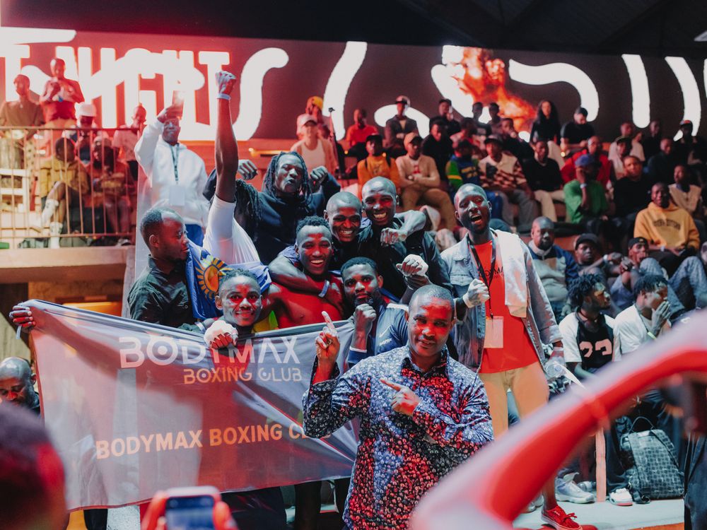 Boxing event crowd cheering with red banners and signs visible in the background.