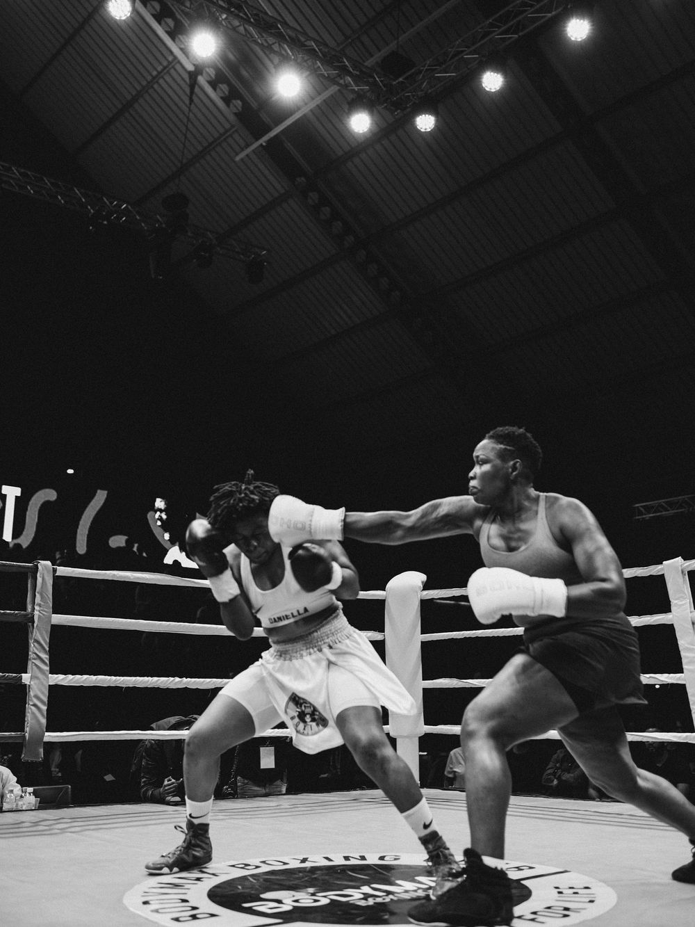 Black and white boxing match photo showing two fighters engaged in intense combat.