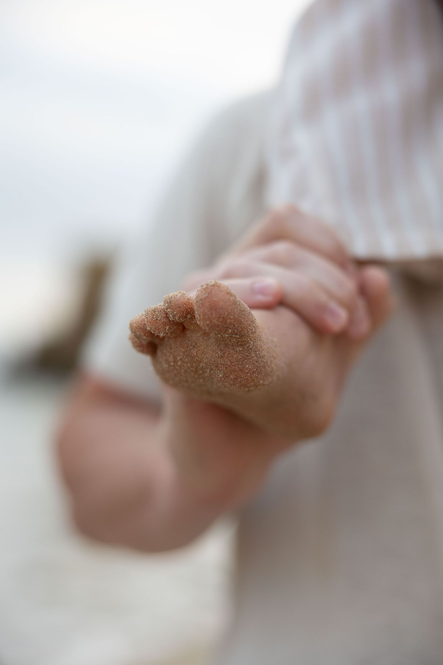 Close-up of hands sprinkling brown sugar or spices in a soft focus artistic composition.