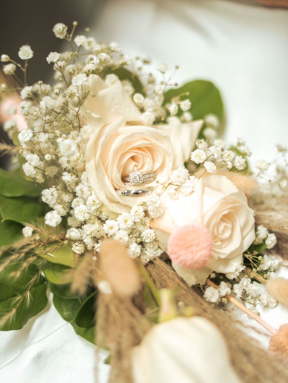 Delicate peach roses and baby's breath flowers arranged in a soft focus wedding bouquet with green foliage in Naples, Florida