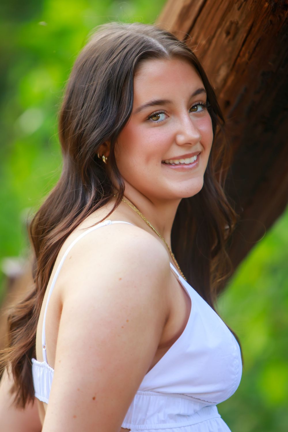 Portrait session in a natural outdoor setting with green foliage background.