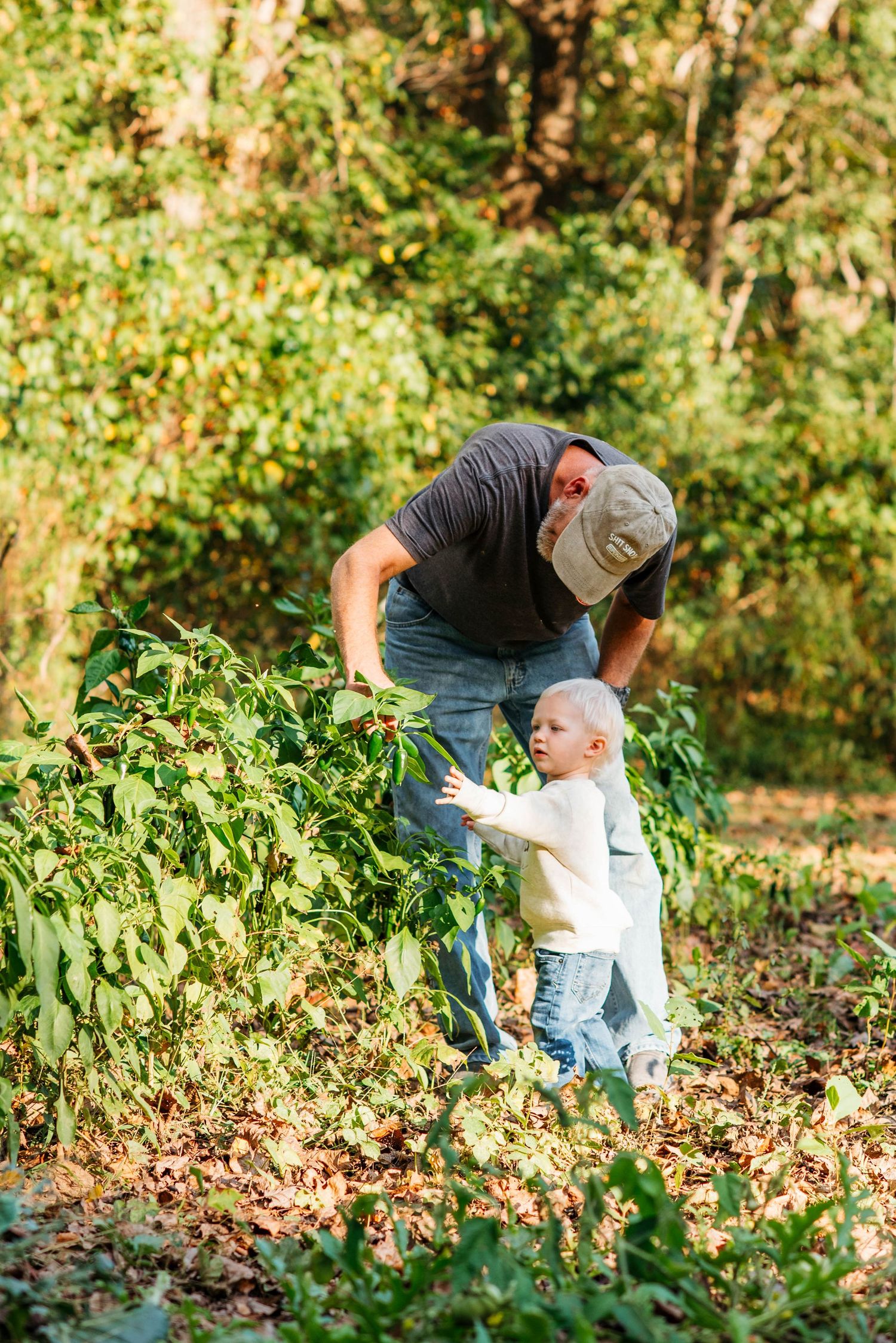 A sweet family moment captured in a garden setting during harvest season.
