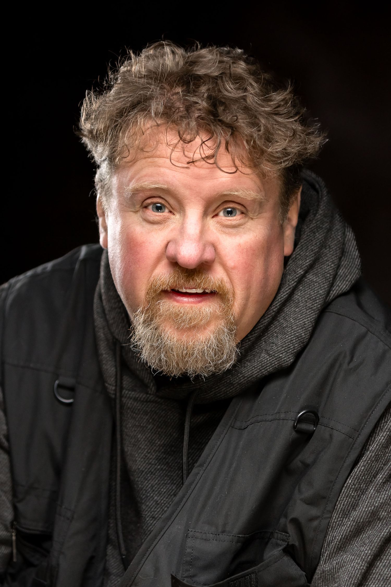 Portrait of person wearing textured sweater against natural background.