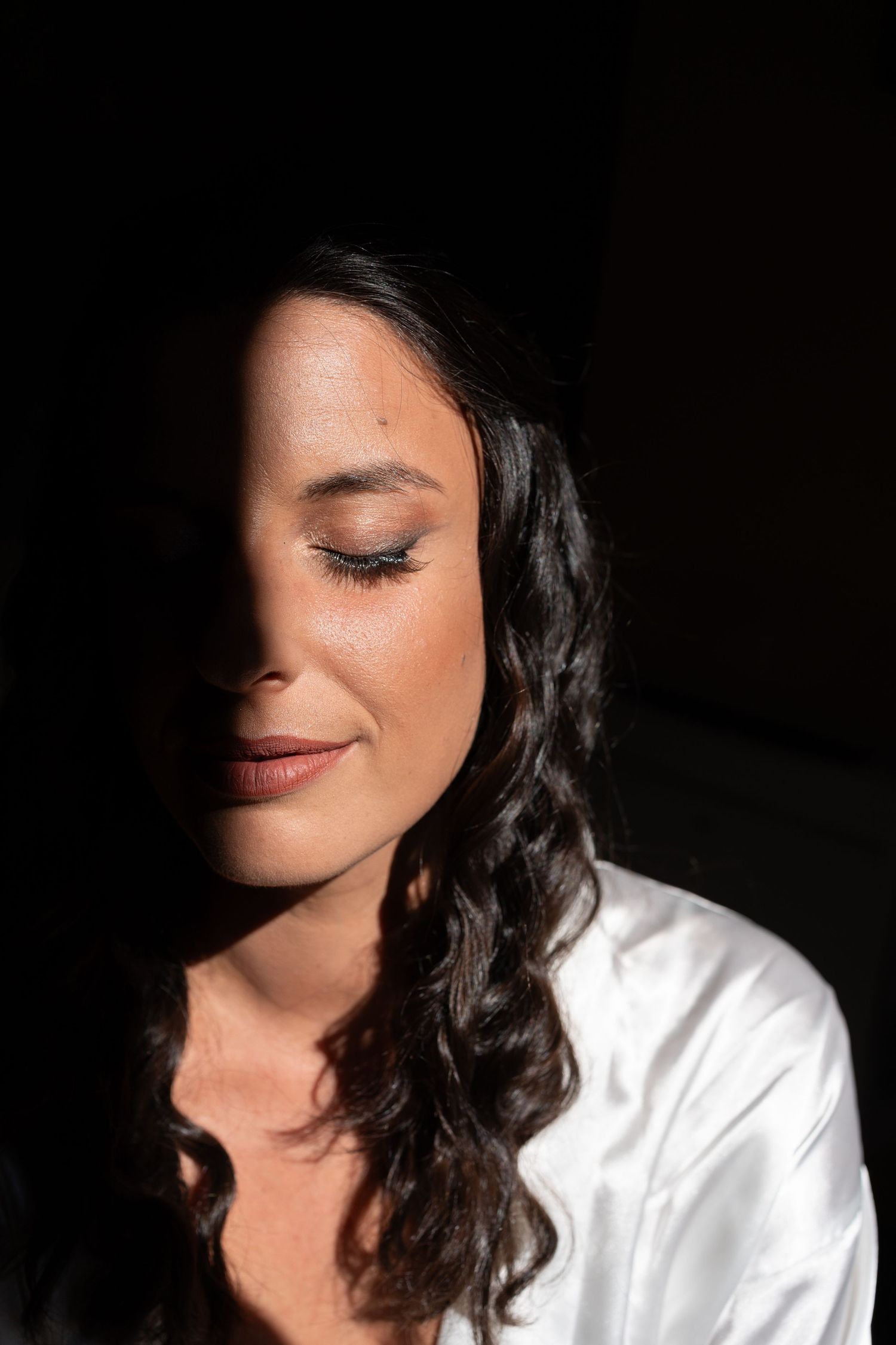 Artistic black and white portrait showing a woman's face partially in shadow.