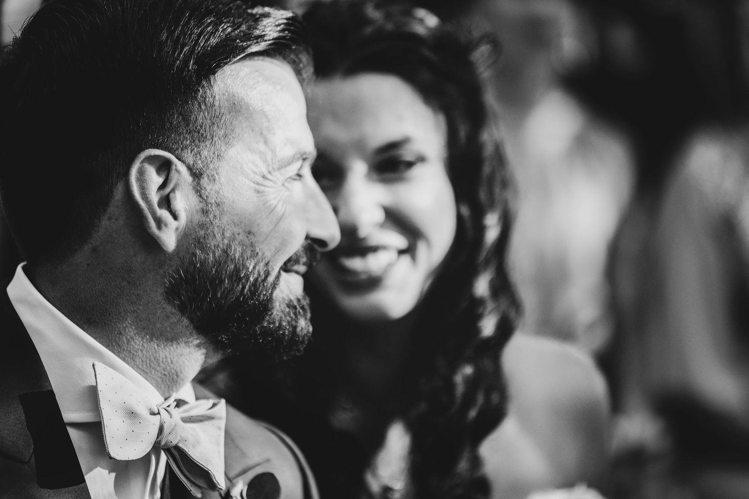 Close up of two people embracing and smiling in black and white.