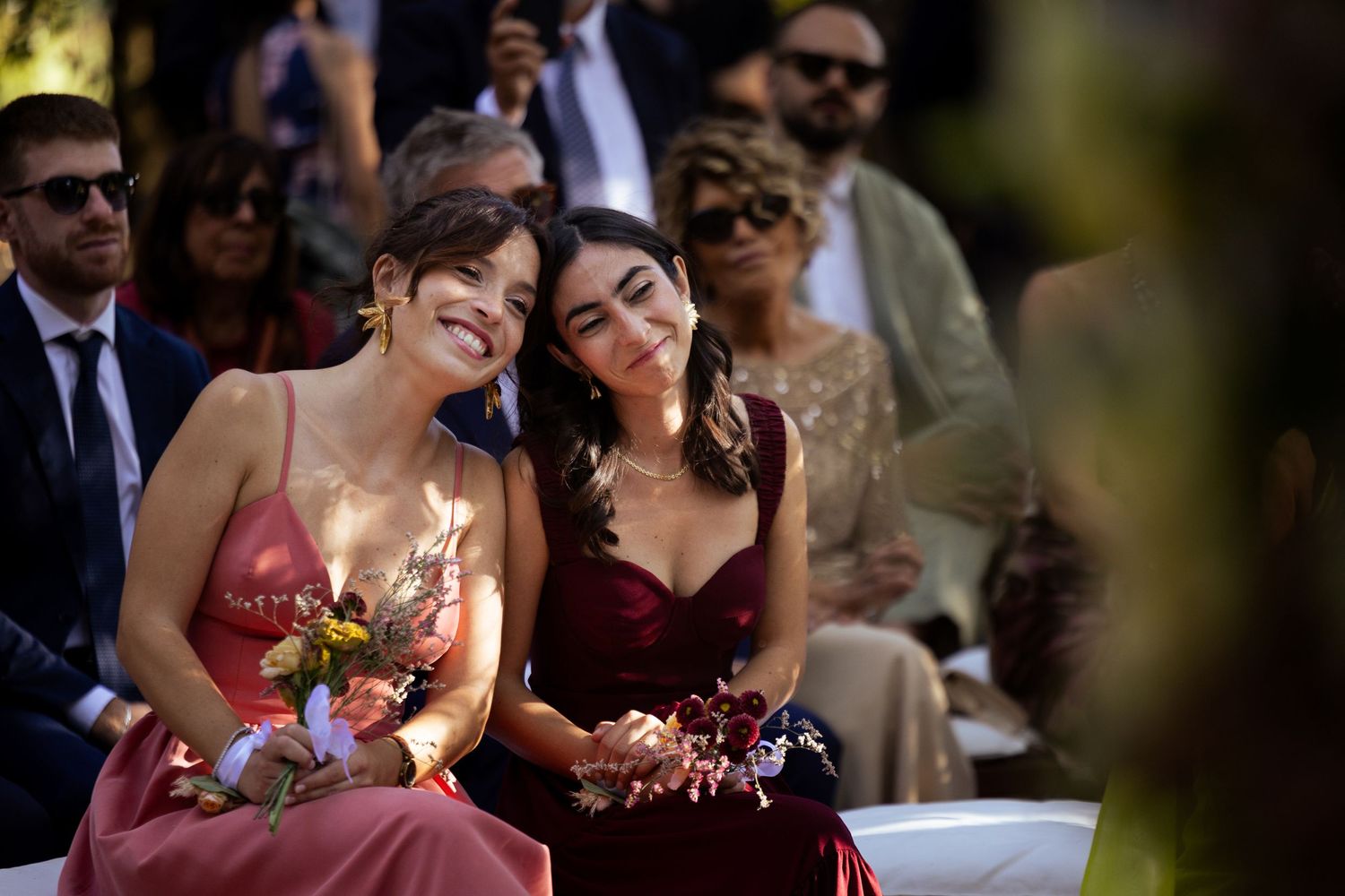 Wedding guests enjoying outdoor celebration with natural lighting and festive atmosphere.