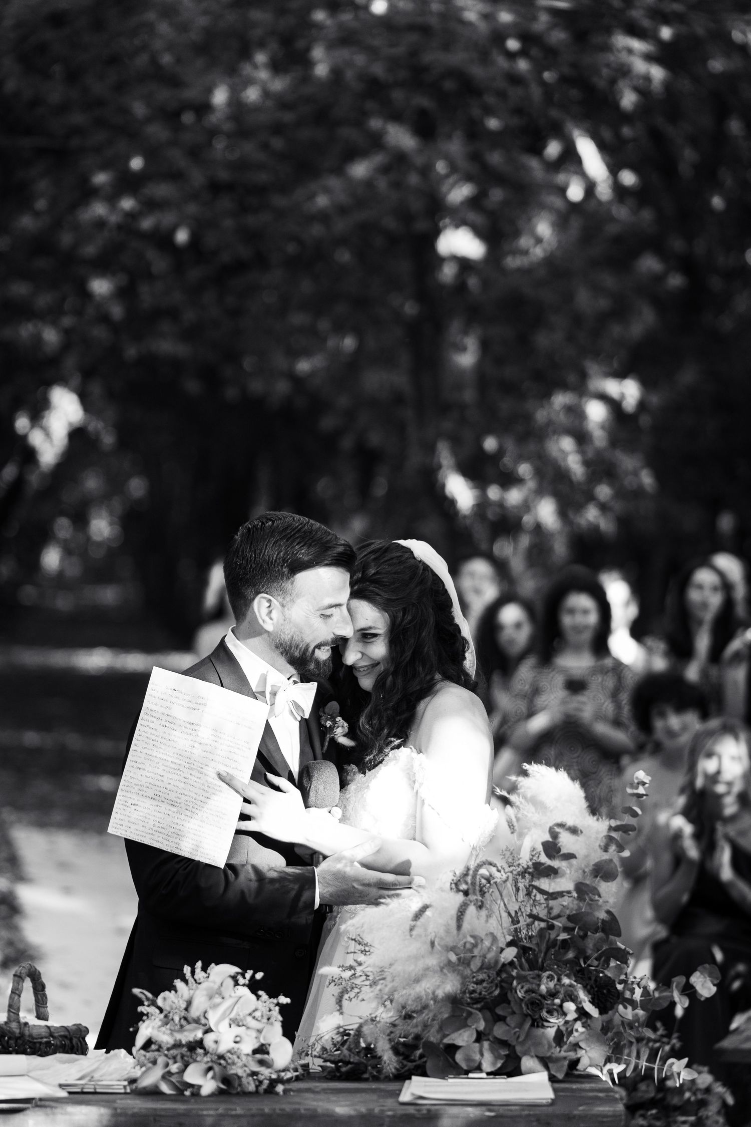 Black and white wedding photo of a couple sharing an emotional moment during their ceremony.