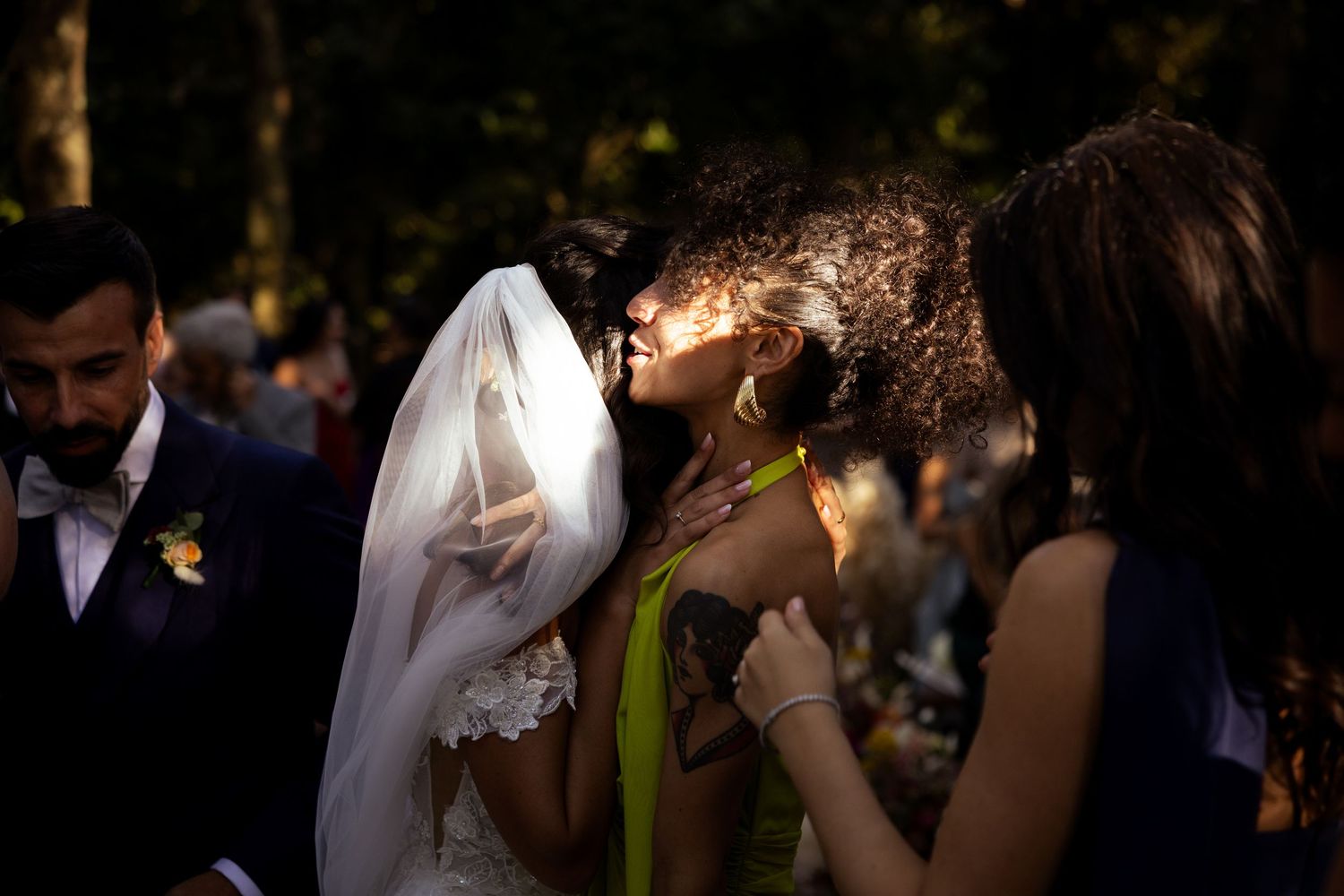 Wedding guests mingling during outdoor evening reception with soft lighting.