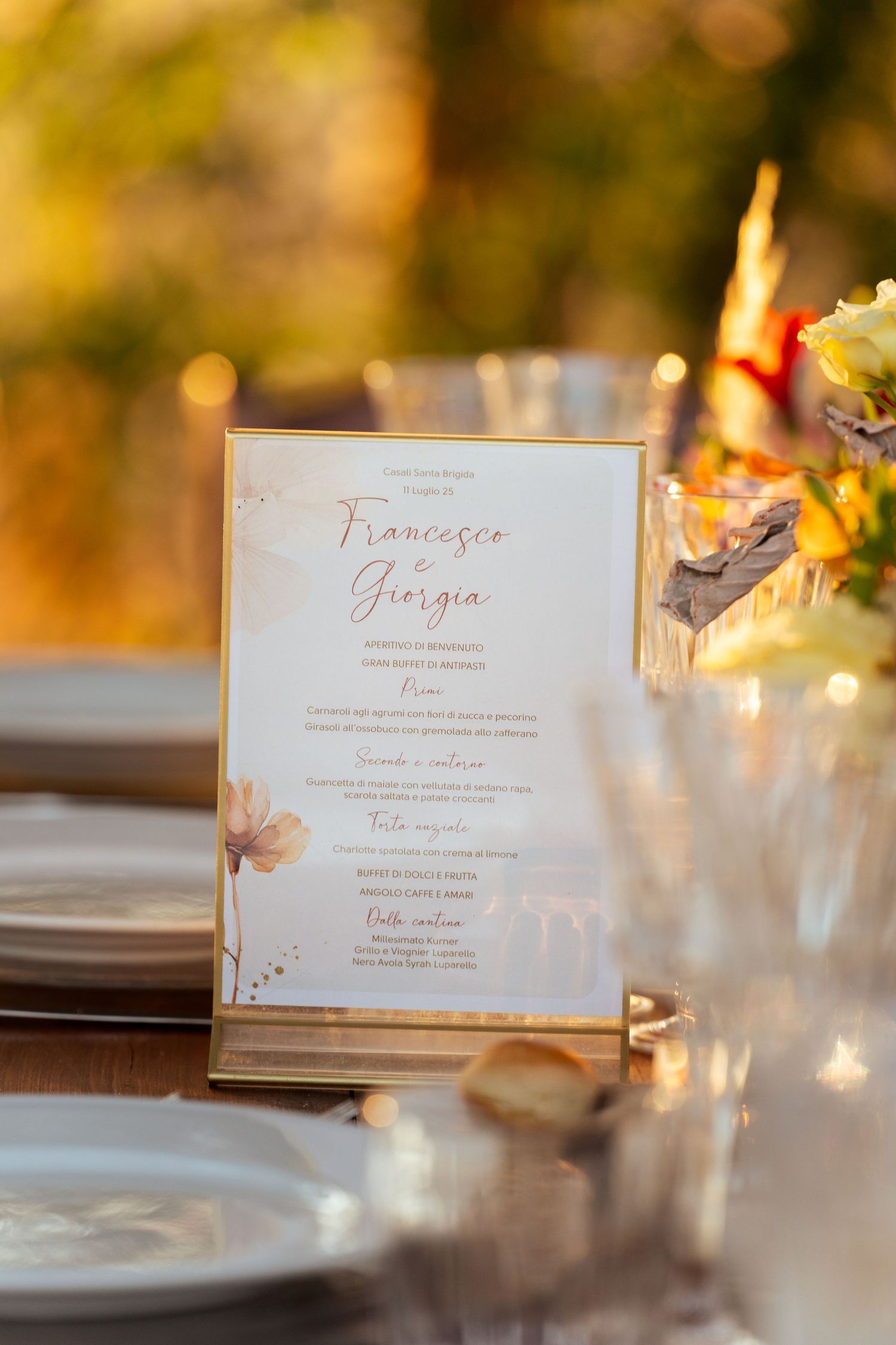 Elegant wedding reception place settings with calligraphed name cards in warm lighting.