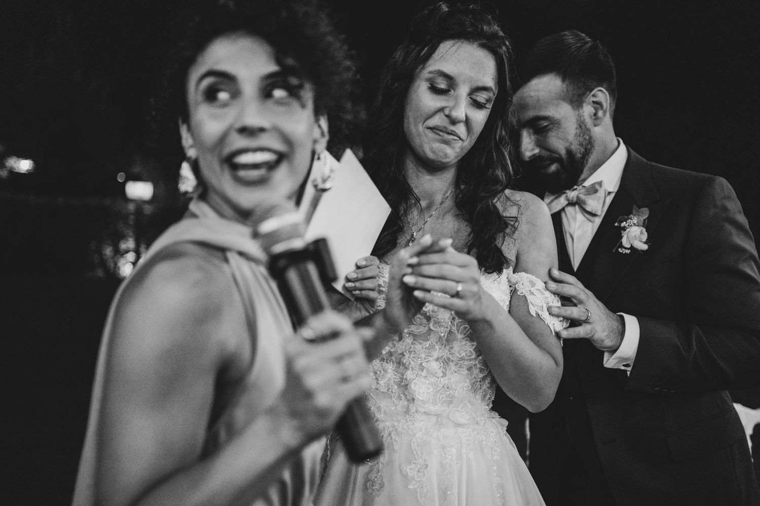 Wedding guests laughing and celebrating during a reception in black and white.