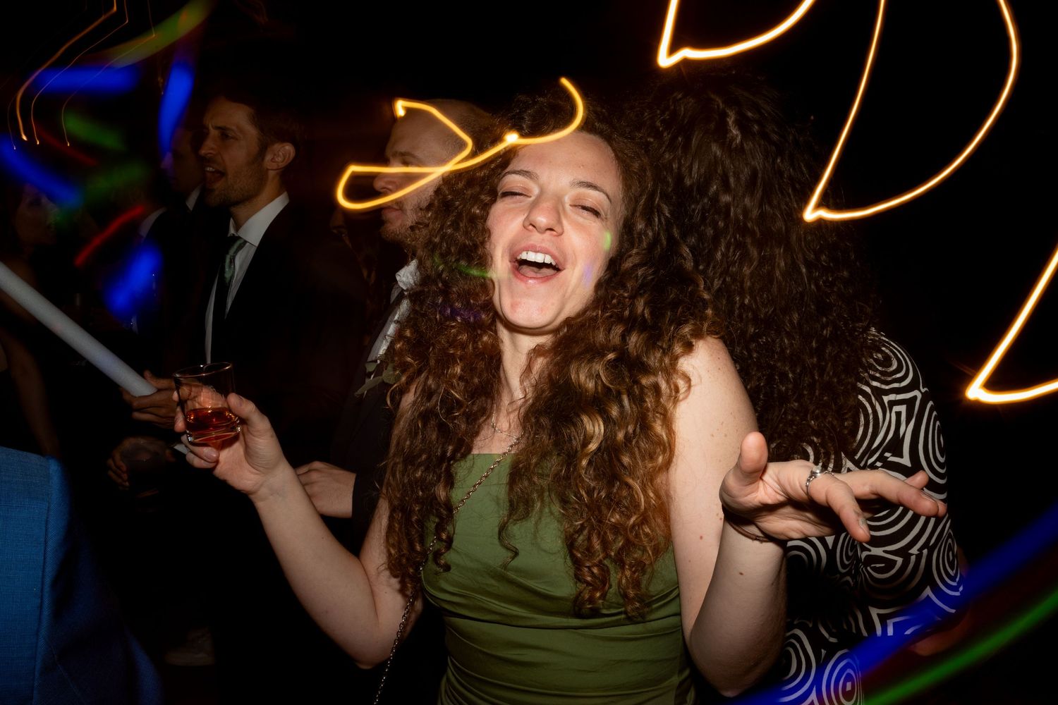 Energetic dance party scene with neon lights and swirling motion effects in a dark nightclub setting.