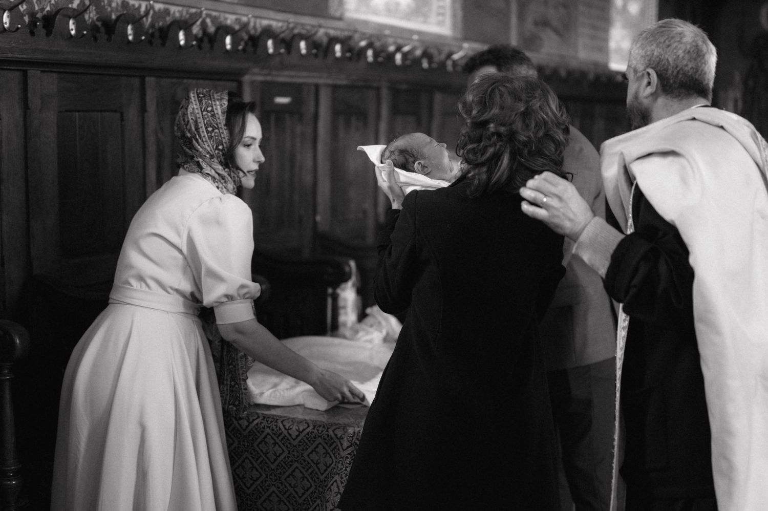 People gathered at a church ceremony in traditional dress, shown in black and white.