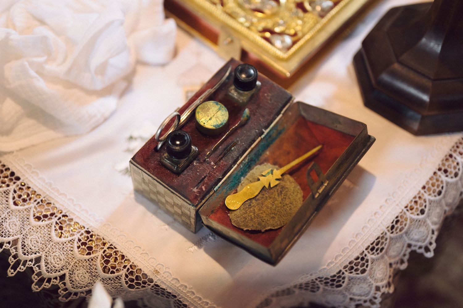 Religious artifacts and cross displayed on lace-covered table.