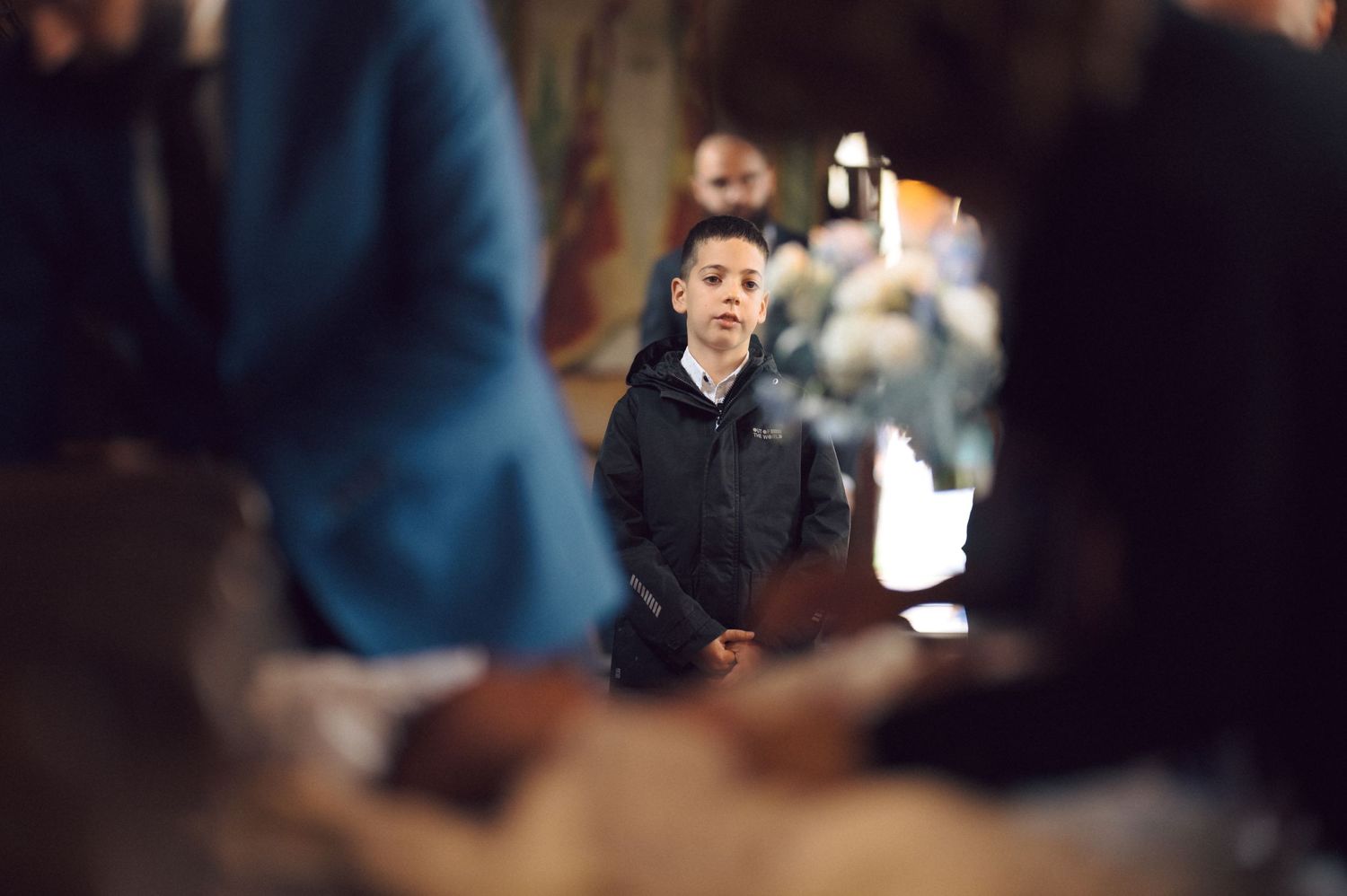 Person taking a photo during a church ceremony with dim lighting and blurred background.
