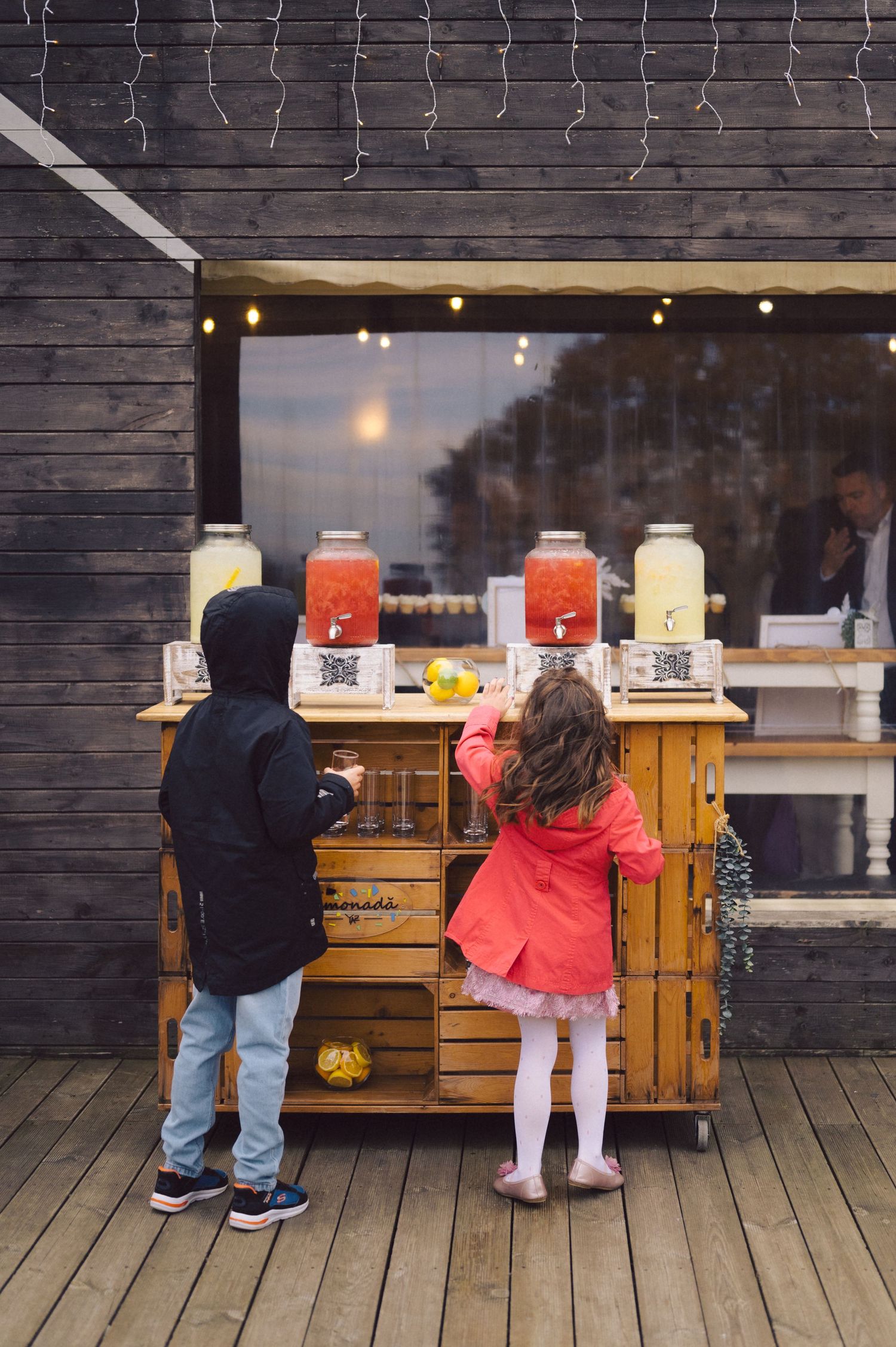 Wooden drink station with large beverage dispensers on rustic deck.