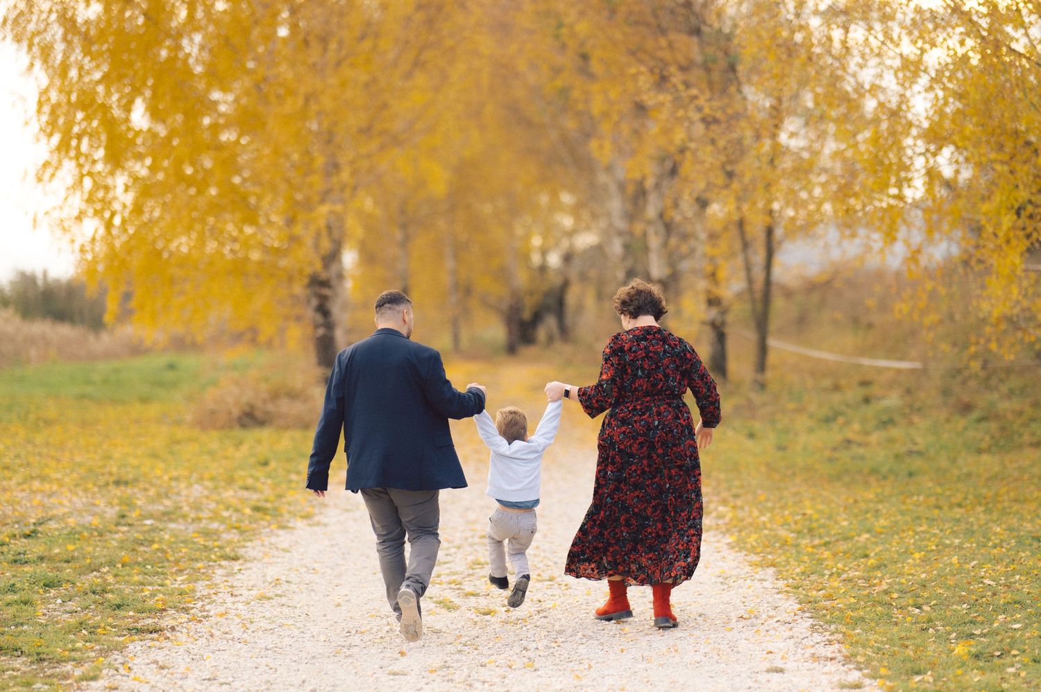 Walking together on an autumn path lined with golden trees.