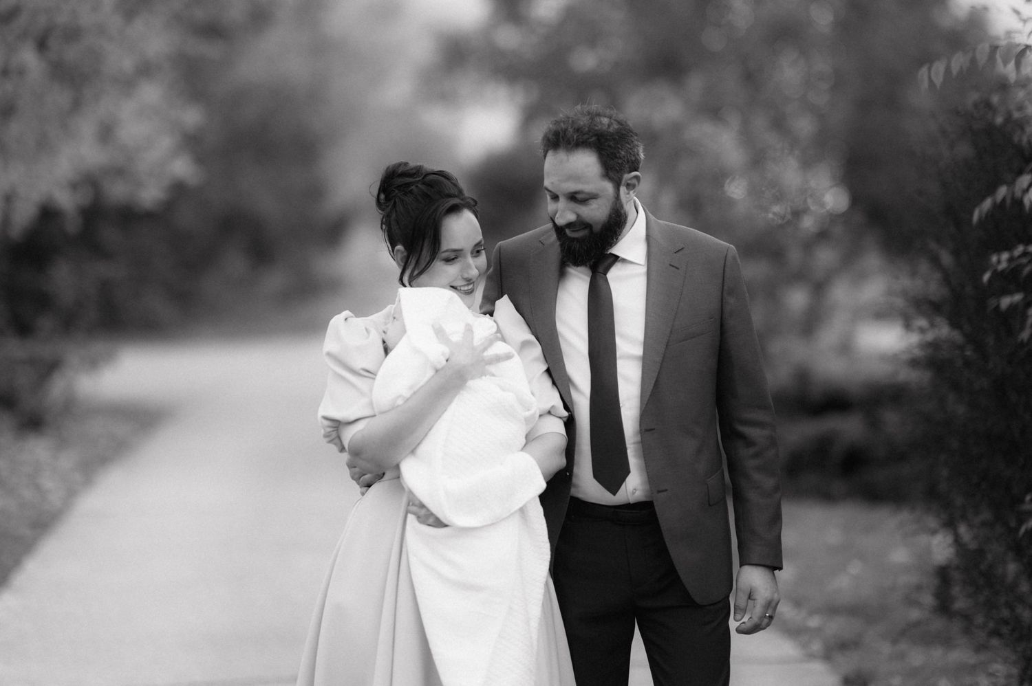 A black and white portrait of a couple walking together on a peaceful path.
