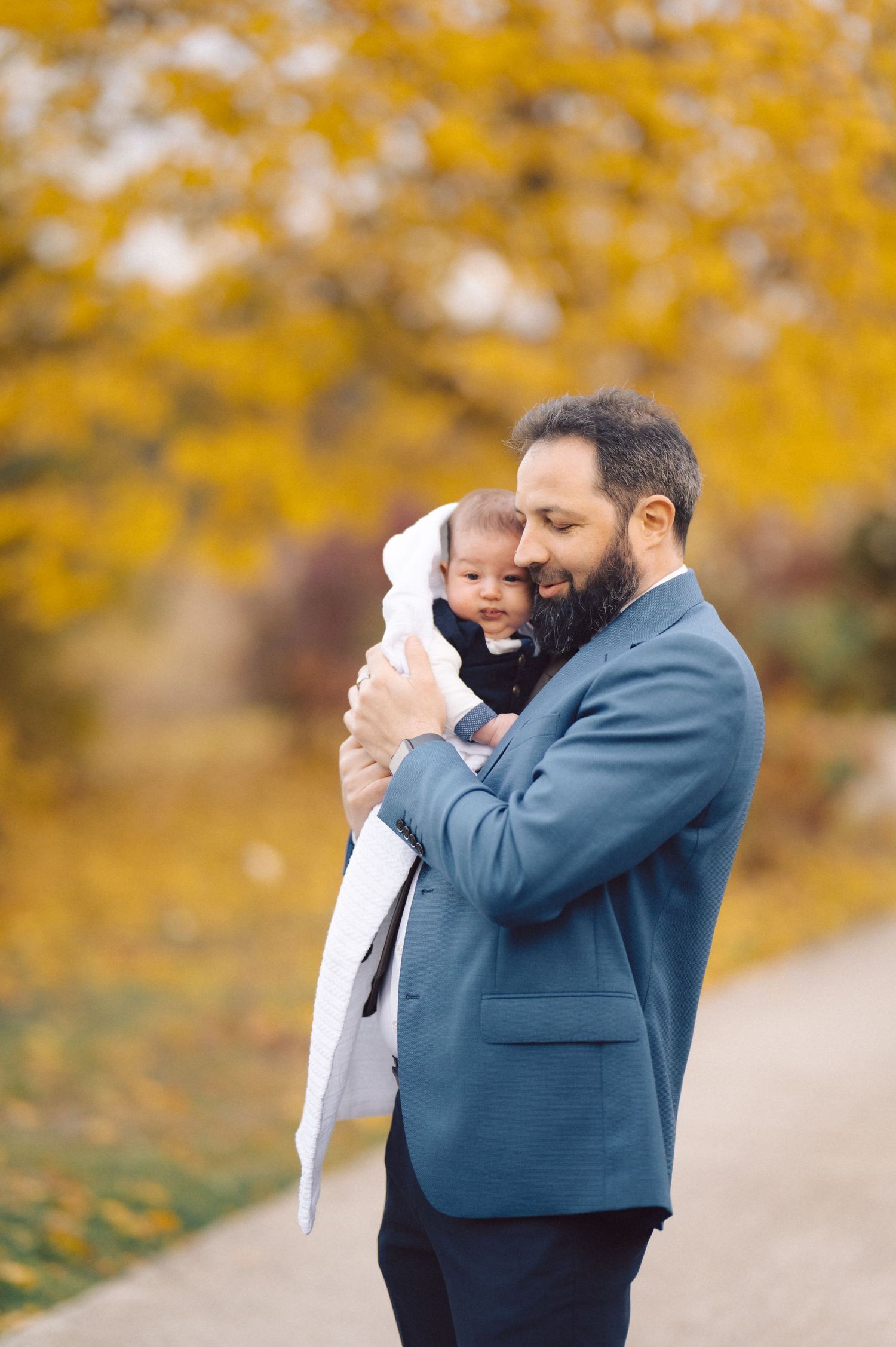 Tender moment with baby against golden autumn background.