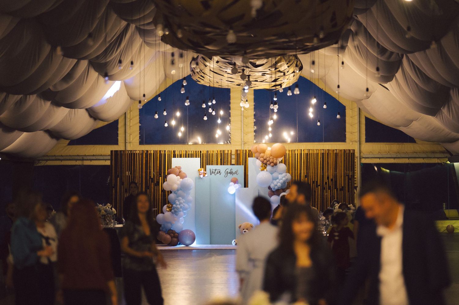 A reception venue decorated with draped fabric and twinkling lights creates a magical ambiance.