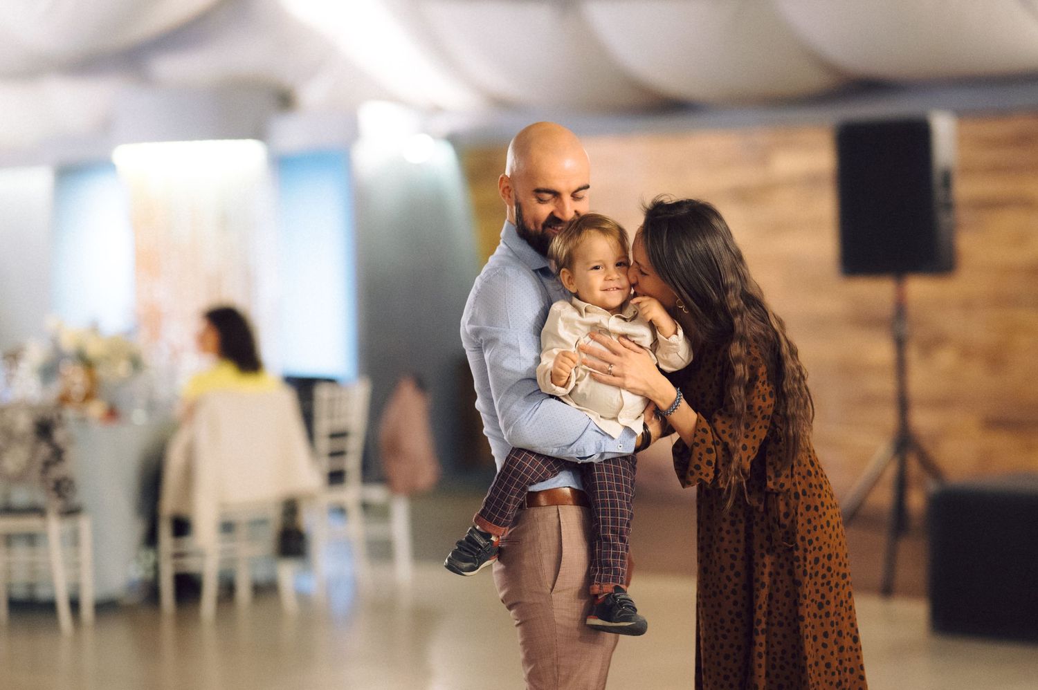 A family shares a tender moment together at an indoor celebration.
