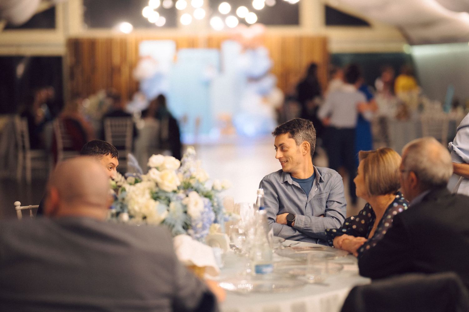 Guest seated at decorated table during an evening reception.