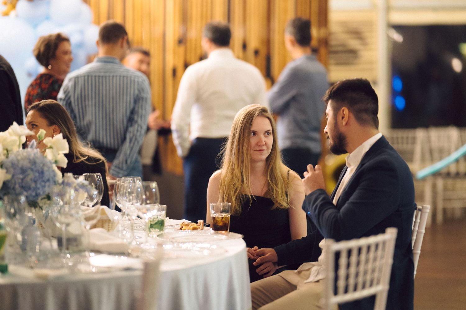 Couple sitting at elegant table setting during formal dinner event.